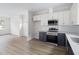 The kitchen area features modern appliances, white and dark blue cabinets, with light wood-look floors at 1448A Maplewood Dr, Durham, NC 27704