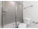 Bright glass enclosed shower with tile surround, a toilet, and a towel bar at 1448A Maplewood Dr, Durham, NC 27704