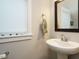 Cozy bathroom with pedestal sink, framed mirror, and a neutral color palette at 1517 Millrock Trl, Wendell, NC 27591