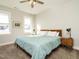 Sunlit bedroom featuring a comfortable bed, ceiling fan, and two bright windows at 1517 Millrock Trl, Wendell, NC 27591