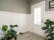 Inviting foyer boasts gray walls, white wainscoting, and stylish plants at 1517 Millrock Trl, Wendell, NC 27591
