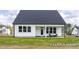 Exterior view of home with backyard, porch, white siding, and dark roof at 152 Cultivator Ct, Angier, NC 27501