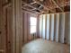 Unfinished living room featuring exposed framing, one window, and plywood flooring at 152 Cultivator Ct, Angier, NC 27501
