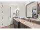 Bathroom with double vanity, stone countertop, dark gray cabinets, and unique framed mirrors at 1616 Hunting Ridge Rd, Raleigh, NC 27615