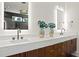 Modern bathroom features dual sinks, sleek faucets, and stylish wood grain cabinets at 1616 Hunting Ridge Rd, Raleigh, NC 27615