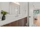 Bright bathroom featuring a modern vanity with sleek hardware, a large mirror, stylish flooring, and a connecting door at 1616 Hunting Ridge Rd, Raleigh, NC 27615
