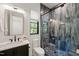 Bathroom with modern vanity, toilet, and glass enclosed shower with beautiful stone pebble floor at 1616 Hunting Ridge Rd, Raleigh, NC 27615