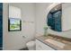 Bright bathroom featuring sleek vanity, commode, and window with a view of exterior at 1616 Hunting Ridge Rd, Raleigh, NC 27615
