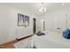 Light filled bedroom featuring hardwood floors, dresser with art, and ensuite bathroom at 1616 Hunting Ridge Rd, Raleigh, NC 27615