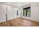 A spacious bedroom with hardwood floors, white walls, and natural light from a black-trimmed window at 1616 Hunting Ridge Rd, Raleigh, NC 27615