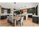Dining area with modern lighting, table for eight, and chef's kitchen at 1616 Hunting Ridge Rd, Raleigh, NC 27615