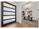 Bright home office with modern desk, stylish light fixture, and view of front door and entry at 1616 Hunting Ridge Rd, Raleigh, NC 27615