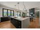 Kitchen island with quartz countertops, black cabinets, and modern pendant lights at 1616 Hunting Ridge Rd, Raleigh, NC 27615