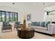 Living room with a modern sofa, oversized windows, a ping-pong table, and a wet bar at 1616 Hunting Ridge Rd, Raleigh, NC 27615
