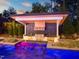 Inviting outdoor kitchen and bar area with built-in grill, sink, and stainless steel appliances near a sparkling pool at 1616 Hunting Ridge Rd, Raleigh, NC 27615