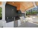 Outdoor kitchen features a stainless steel grill, black countertops, and a wooden ceiling at 1616 Hunting Ridge Rd, Raleigh, NC 27615