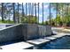 Luxury pool with tiled water feature and stone walkway, surrounded by lush trees at 1616 Hunting Ridge Rd, Raleigh, NC 27615