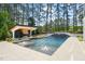 Backyard pool with fountains, water feature, and outdoor kitchen surrounded by lush greenery at 1616 Hunting Ridge Rd, Raleigh, NC 27615