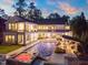 Stunning rear exterior featuring a luxurious pool, hot tub, patio, balconies, and outdoor kitchen area at 1616 Hunting Ridge Rd, Raleigh, NC 27615