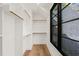 Walk-in closet with white shelving and storage, complemented by hardwood floors and a large window at 1616 Hunting Ridge Rd, Raleigh, NC 27615