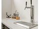 Close-up of a modern wet bar with stainless steel beer taps, countertops, and bar accessories at 1616 Hunting Ridge Rd, Raleigh, NC 27615