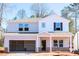 Two-story home features an attached two-car garage, neutral color palette, and craftsman-style front door at 169 Klamath Dr, Garner, NC 27529