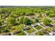 Aerial view showcases homes with expansive yards, surrounded by vibrant green trees and clear skies at 1802 Prince Edward Dr, Elon, NC 27244