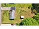 Aerial view of the home showcasing a large yard, detached garage, and surrounding greenery at 1802 Prince Edward Dr, Elon, NC 27244