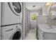 Bathroom with white vanity, shower with patterned curtain, and stacked washer/dryer at 1802 Prince Edward Dr, Elon, NC 27244