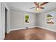 Bedroom with hardwood floor, ceiling fan, and view of the backyard at 1802 Prince Edward Dr, Elon, NC 27244