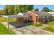 Exterior view of the home boasting a covered parking area, brick facade, and well-manicured yard at 1802 Prince Edward Dr, Elon, NC 27244