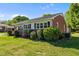 Exterior of home featuring brick facade, manicured landscaping, and roof overhang at 1802 Prince Edward Dr, Elon, NC 27244