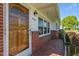 Welcoming front porch with patterned tile, brick accents, and a charming wooden front door at 1802 Prince Edward Dr, Elon, NC 27244