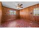 Cozy living room with wood-paneled walls, vintage ceiling fan and natural lighting at 1802 Prince Edward Dr, Elon, NC 27244