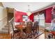 Elegant dining room featuring red walls, a crystal chandelier, and hardwood floors at 192 Ash Lily Ct, Nashville, NC 27856