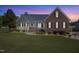 Charming two-story home showcasing a landscaped yard, brick accents, and inviting front porch at twilight at 192 Ash Lily Ct, Nashville, NC 27856