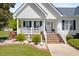 Inviting front porch with white railings, brick steps, manicured landscaping, and a welcoming front door at 192 Ash Lily Ct, Nashville, NC 27856