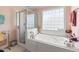 Main bathroom featuring a soaking tub, a separate shower, and a glass block window at 192 Ash Lily Ct, Nashville, NC 27856