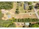 Aerial view of the property showing a brick home, detached garages, a pool, and surrounding greenery at 19461 Nc Highway 210, Angier, NC 27501