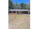 Front view of a brick house showing a well-kept lawn and front door, and screened porch at 19461 Nc Highway 210, Angier, NC 27501