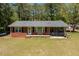 Inviting brick home featuring a cozy screened porch, bench, black shutters, and well-maintained lawn at 19461 Nc Highway 210, Angier, NC 27501