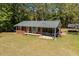 Lovely brick home with a screened-in porch, bench, flag, and a beautifully landscaped yard surrounded by trees at 19461 Nc Highway 210, Angier, NC 27501