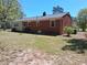 Backyard view of a brick home showing windows, lawn, trees, and back of the house at 19461 Nc Highway 210, Angier, NC 27501