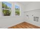 A bright laundry room with hardwood floors, shelving, and two windows at 2019 James St, Durham, NC 27707