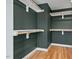 Empty walk-in closet with hardwood floors, shelving and custom wooden clothing rods at 2019 James St, Durham, NC 27707