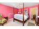Bright pink bedroom with four-poster bed, ceiling fan, doorway and carpet floors at 205 Lippershey Ct, Cary, NC 27513