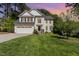 Beautiful two-story white home with a well-manicured lawn and a two-car garage on a sunny day at 205 Lippershey Ct, Cary, NC 27513