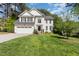 Beautiful two-story white home with a well-manicured lawn and a two-car garage on a sunny day at 205 Lippershey Ct, Cary, NC 27513