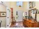 Inviting foyer with hardwood floors, large windows and a vintage wooden cabinet beneath a decorative mirror at 205 Lippershey Ct, Cary, NC 27513