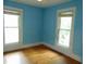 A simple bedroom with two windows and hardwood floors at 223 S Main St, Wendell, NC 27591